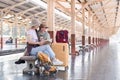 Two Asian female tourist friends are at the train station. Waiting for the train to travel to the provinces together on