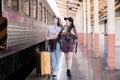 Two Asian female tourist friends are at the train station. Waiting for the train to travel to the provinces together on