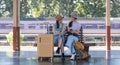 Two Asian female tourist friends are at the train station. Waiting for the train to travel to the provinces together on