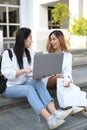 Two Asian female university students sitting at the outdoor building stairs Royalty Free Stock Photo