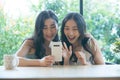 Two Asian friends using mobile phones making video call. Royalty Free Stock Photo