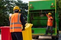 Two Asian Garbage men working together on emptying dustbins for trash removal. Garbage collector Royalty Free Stock Photo