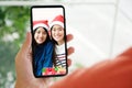 Two asian girl video call for greeting in Christmas celebration, Hand holding mobile phone while talking with asia females in