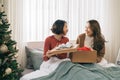Two asian girlfriends exchanging christmas presents Royalty Free Stock Photo