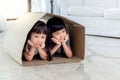 Two Asian girls, aged 5 and 3, were playing hide and seek in a paper box Royalty Free Stock Photo