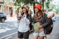 two Asian girls backpacking to find tourist destinations with cameras and maps