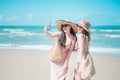 Two Asian girls are relaxing, taking pictures, playing on the beach