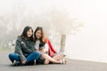 Two asian girls Very close friends Wearing a sweater, take a selfie phone, Along the road beside the reservoir in the thick fog Wi Royalty Free Stock Photo