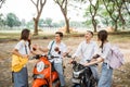 Two asian high school girls chat while boys on motorbikes