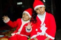 Two Asian Indian Ethnicity kids wearing Santa Hat waving having Royalty Free Stock Photo