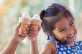 Two asian little girls holding melting ice cream waffle cone Royalty Free Stock Photo