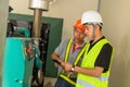 Two asian maintenance technician checking technical data of water pressure control system equipment in factory Royalty Free Stock Photo