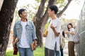 Two Asian male student friends are enjoying talking while walking on a footpath on their campus Royalty Free Stock Photo