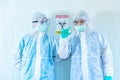 Two ASIAN medical staffs wear PPE suit and medical gloves showing COVID-19 vaccine in quarantine room