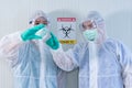 Two ASIAN medical staffs wear PPE suit and medical gloves showing something in the air in quarantine room