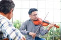 Two asian men playing the violin classical instrumental and acoustic guitar