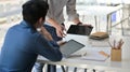 Two asian men using a tablet. They consulted the job to present clients in a contemporary office