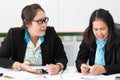 Two asian mid age female colleagues working and doing a presentaion together in office. Royalty Free Stock Photo