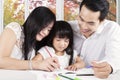 Two asian parents teach their child to write Royalty Free Stock Photo