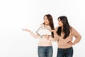 Two asian positive ladies sisters holding arrow showing copyspace.