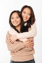 Two asian pretty smiling ladies sisters hugging