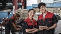 Two Asian professional automotive mechanics working at a service garage. Royalty Free Stock Photo