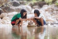 Two asian siblings playing sand nearing the river together with fun. Royalty Free Stock Photo