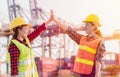 Two asian staff woman in yellow safety helmet with standing and putting hands up