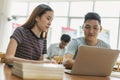 Two asian students researching for project in library