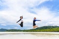 Two asian teen girls friends jumping enjoy on the beach Royalty Free Stock Photo