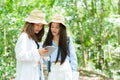 Two Asian teenage girls are best friends, another friend is holding tablet in hand look at walking directions, walking maps in Royalty Free Stock Photo