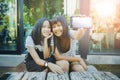 Two asian teenager show white screen of smart phone screen and toothy smiling face happiness emotion Royalty Free Stock Photo