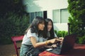 Two asian teenager typing on computer labtop happiness emotion Royalty Free Stock Photo