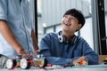 Two Asian teenagers constructing robot project in science classroom