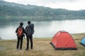 Two asian travelers standing near lake