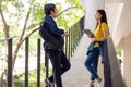 Two Asian university students walking and conversing to class in a magnificent campus building`s walkway Royalty Free Stock Photo