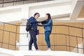 Two Asian university students walking and conversing to class in a magnificent campus building`s walkway Royalty Free Stock Photo