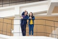 Two Asian university students walking and conversing to class in a magnificent campus building`s walkway Royalty Free Stock Photo