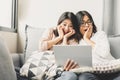 Two asian woman feelig surprise and excite watching in tablet