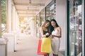 Two asian woman standing at store front with happy watching smart phone at shopping mall center Royalty Free Stock Photo