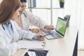 Two asian women doctors discuss meeting doctor`s office medical clinic using laptop consulting patient disease. Asian medical lab Royalty Free Stock Photo