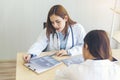 Two asian women doctors discuss meeting doctor`s office medical clinic using laptop consulting patient disease. Asian medical lab Royalty Free Stock Photo