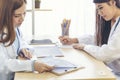 Two asian women doctors discuss meeting doctor`s office medical clinic using laptop consulting patient disease. Asian medical lab Royalty Free Stock Photo