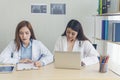 Two asian women doctors discuss meeting doctor`s office medical clinic using laptop consulting patient disease. Asian medical lab Royalty Free Stock Photo