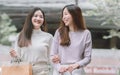 Two asian women doing window shopping together