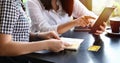 Two Asian women drinking coffee in a cafe and shopping online on smart phones Royalty Free Stock Photo