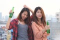 Two asian women drinking at rooftop party, outdoors celebration, friendship, LGBT couple concept Royalty Free Stock Photo