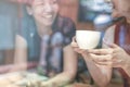 Two Asian women,friends having a free time drinking coffee at cafe. Friends laughing together while drinking a coffee in the