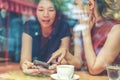 Two Asian women,friends having a free time drinking coffee at cafe. Friends laughing together while drinking a coffee in the Royalty Free Stock Photo