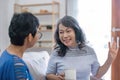 Two Asian women are sitting drinking coffee and chatting in the living room. Royalty Free Stock Photo